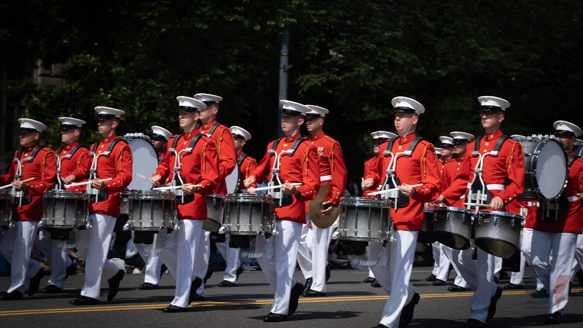 Drummers in red uniforms marching in a parade.