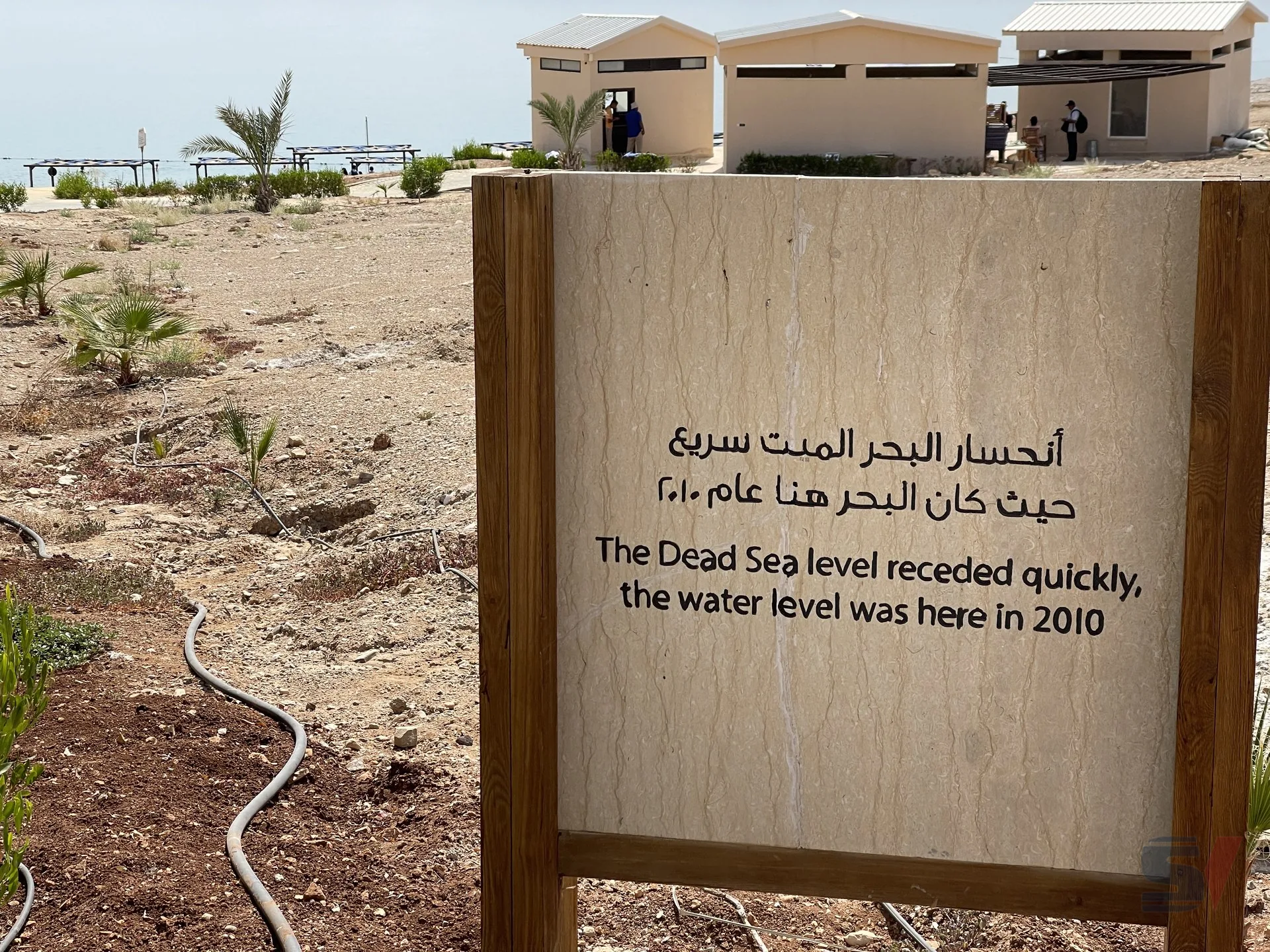 Sign indicating the receding water level of the Dead Sea.