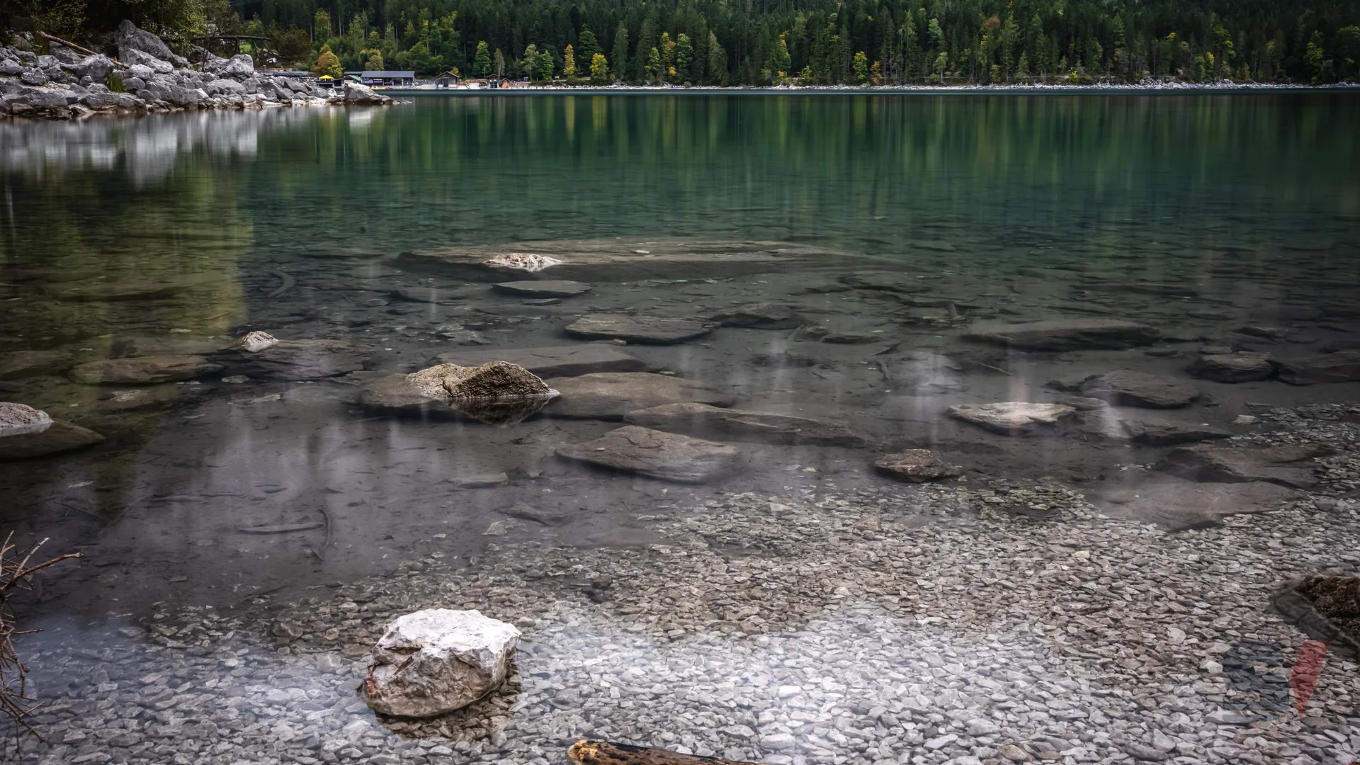 Clear turquoise waters of Eibsee Lake with visible stones and reflections.