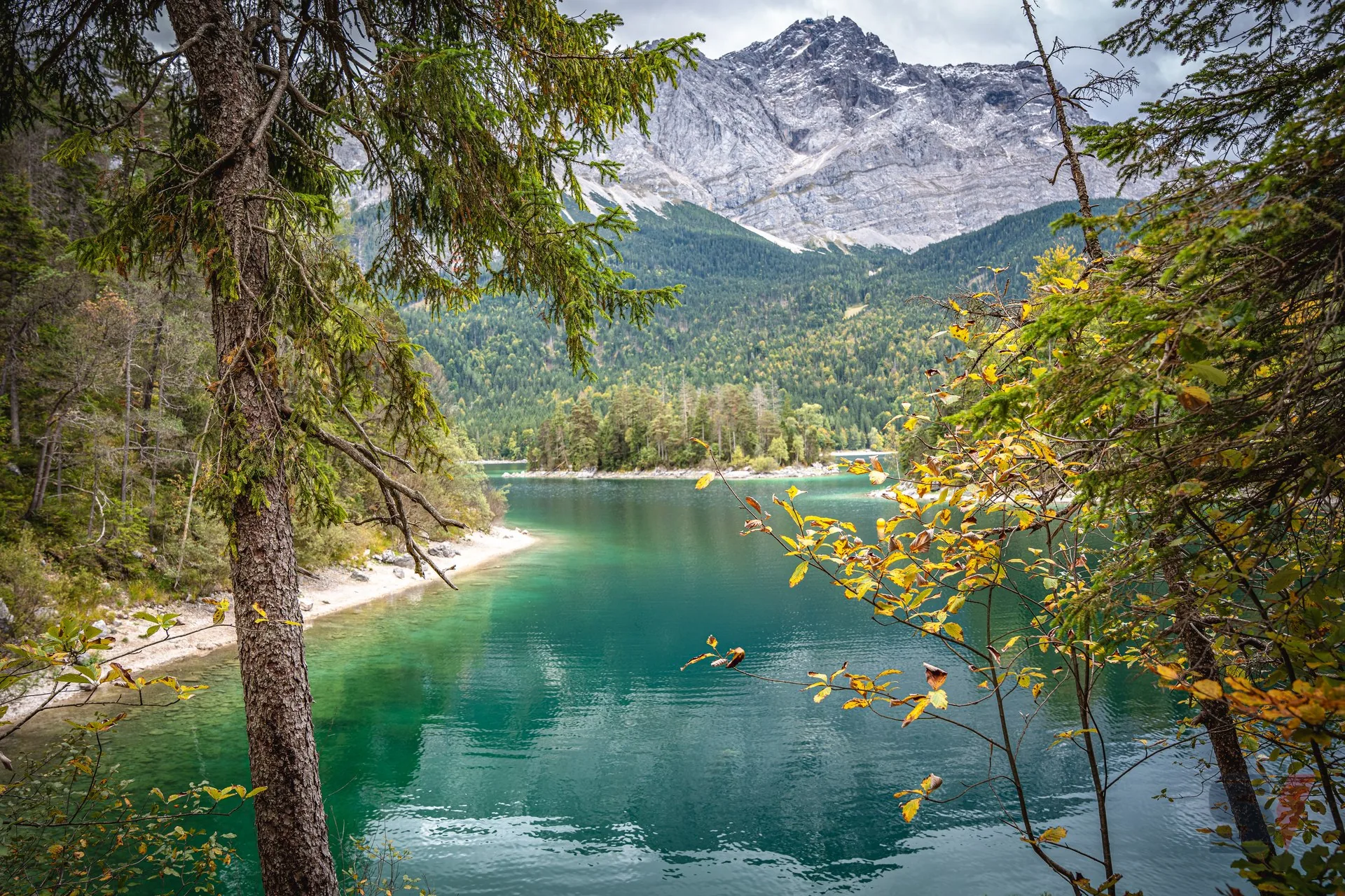 Herbstlandschaft am Eibsee mit türkisfarbenem Wasser und Bergen.