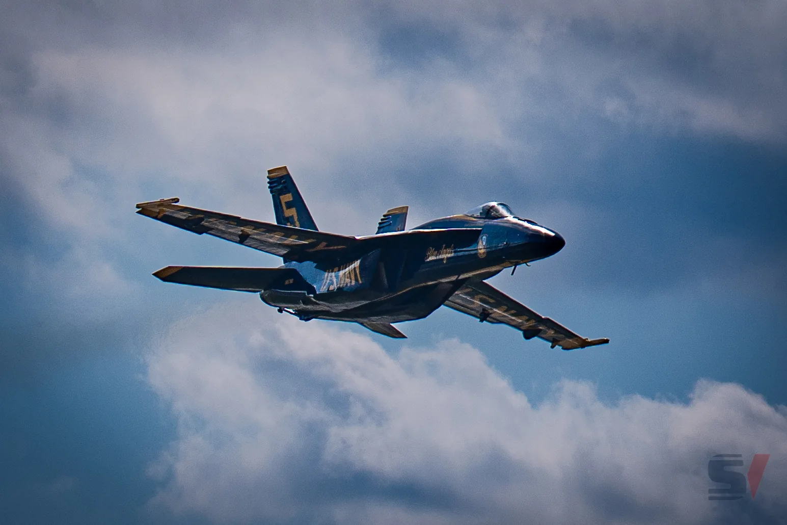A Blue Angels F/A-18 Hornet flying through the sky at the NAS Oceana Air Show.