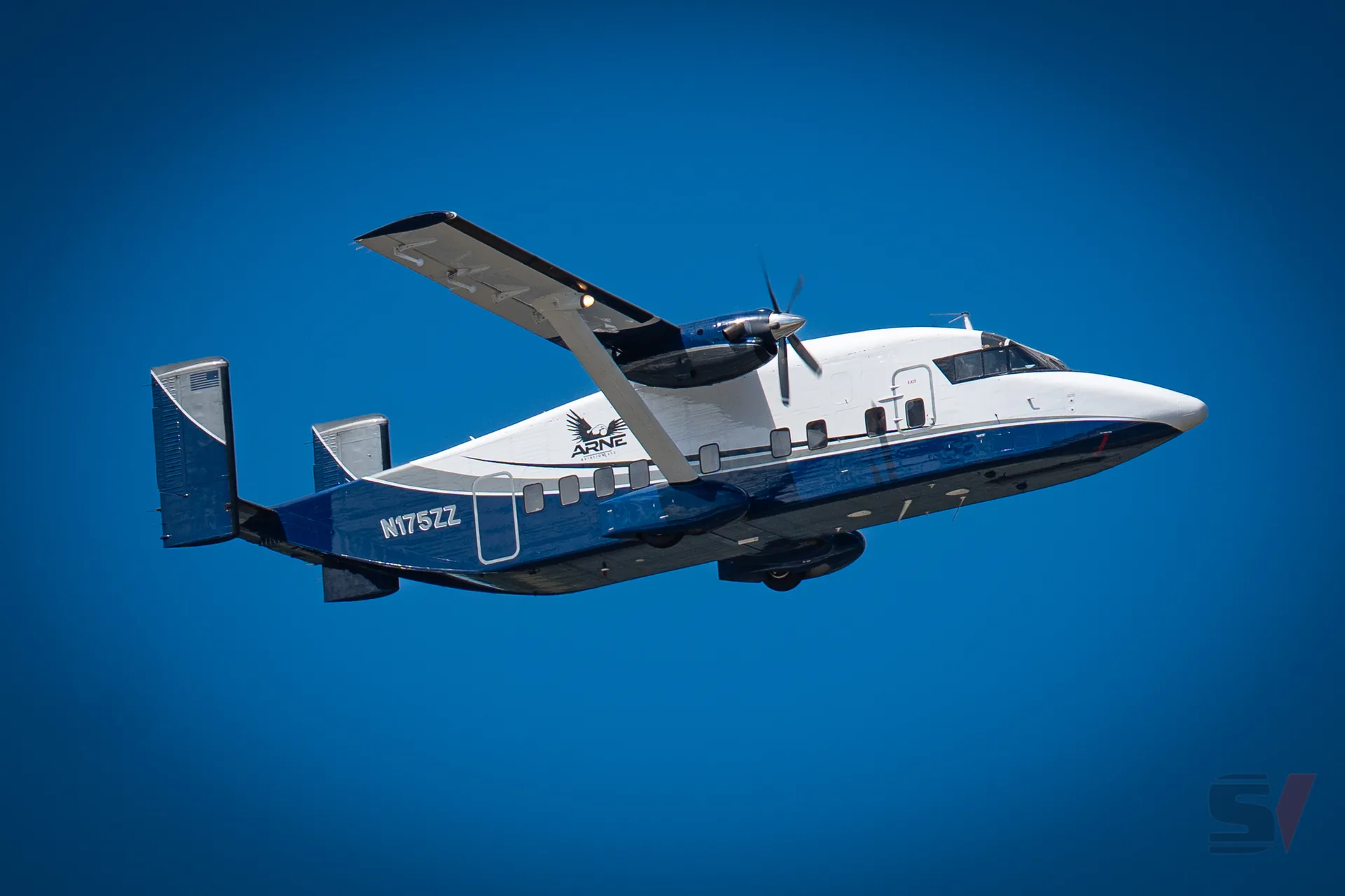 A DHC-6 Twin Otter aircraft flying against a clear blue sky at NAS Oceana.